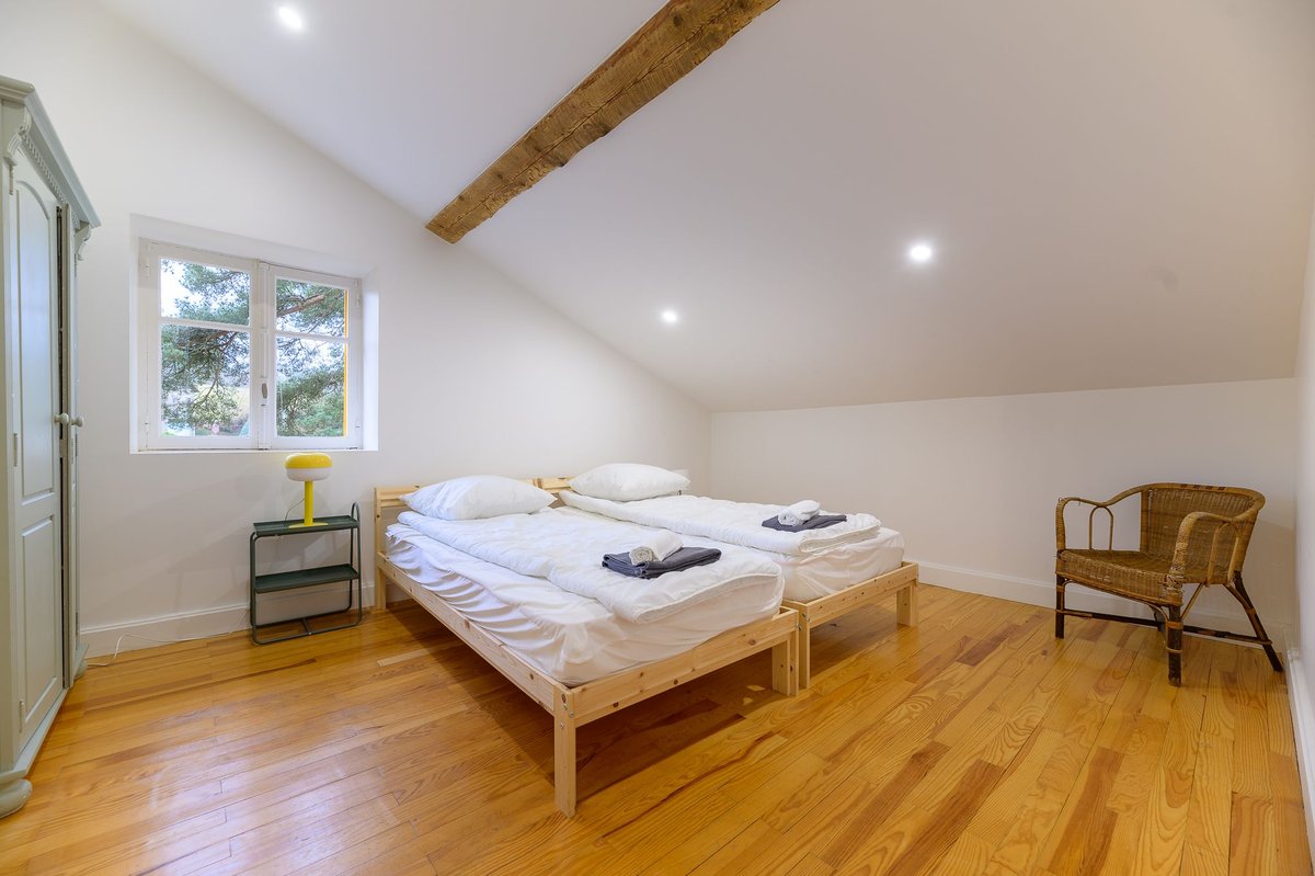 Chambre sous les combles avec poutres apparentes dans le gîte Beaujolais